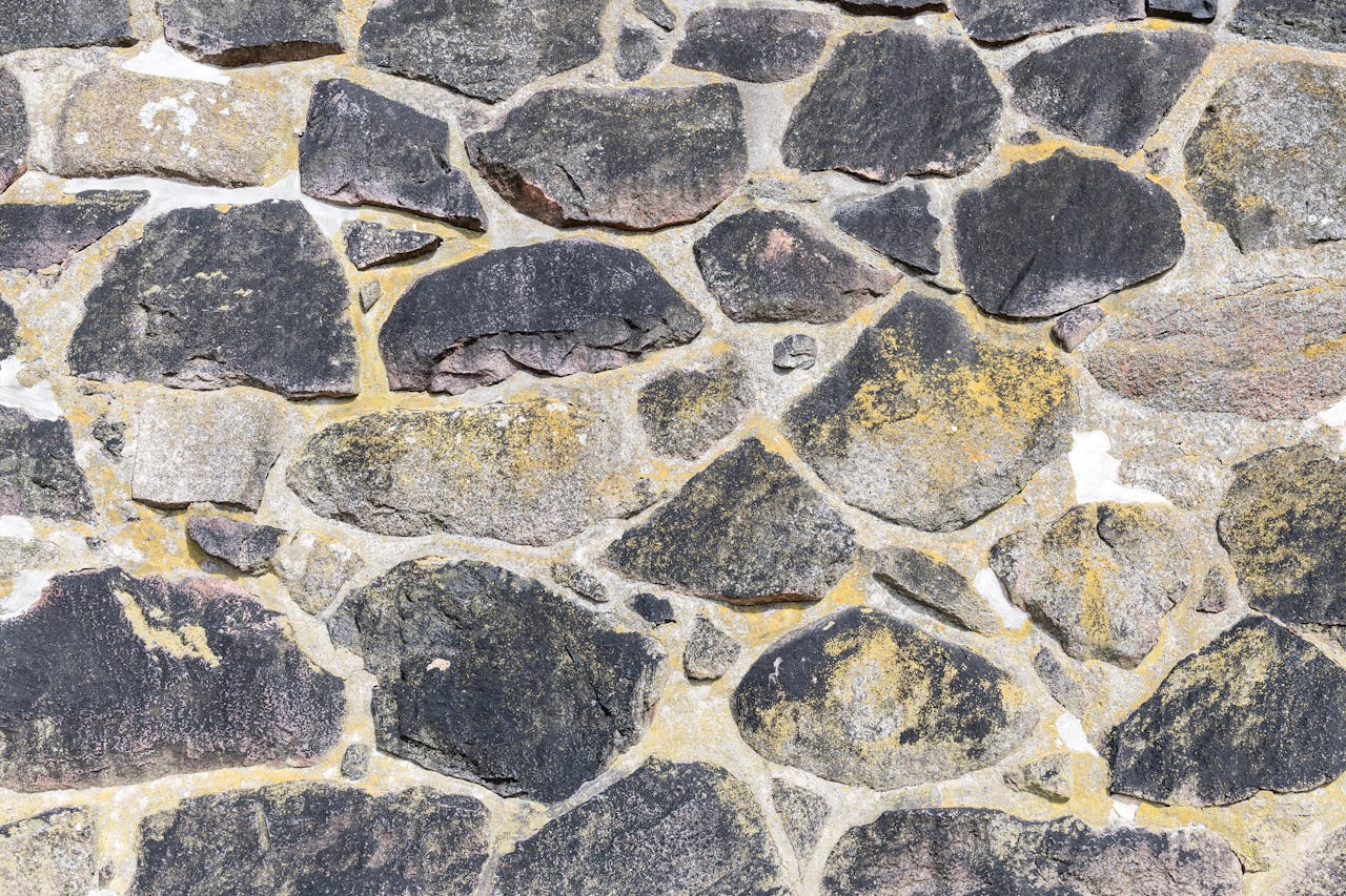 Close-up of an ancient stone masonry wall showcasing natural rock textures and patterns.